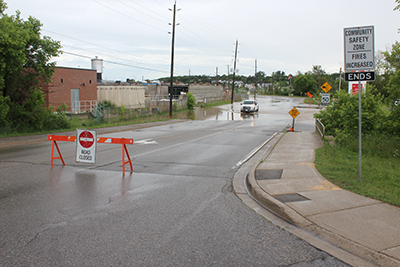 SEVERAL AREAS in Orangeville found itself under water on Friday (June 23) as a relentless thunderstorm drenched the community. Above, a municipal truck drives through the water on Town Line to inspect the road’s manhole covers.